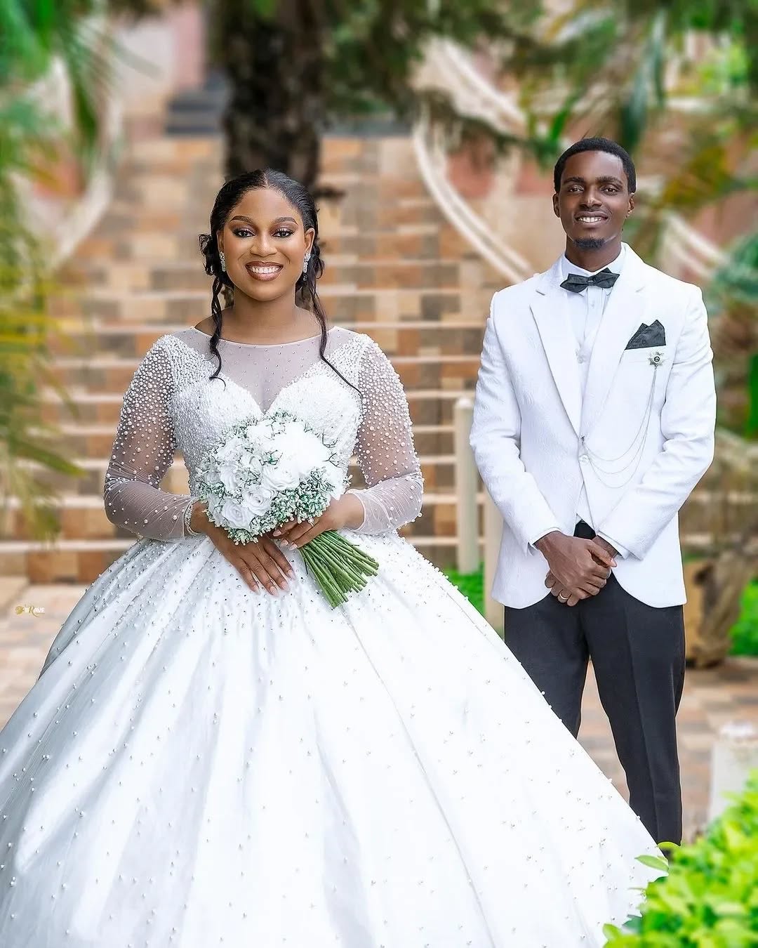 Bride and groom outdoors, bride in a pearl ball gown