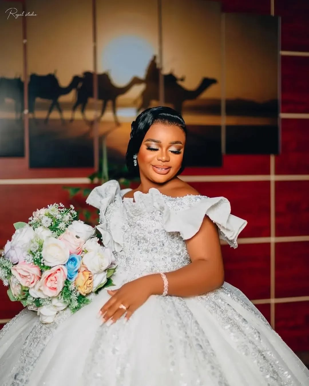 Bride in a ruffled off-shoulder gown holding a pastel bouquet